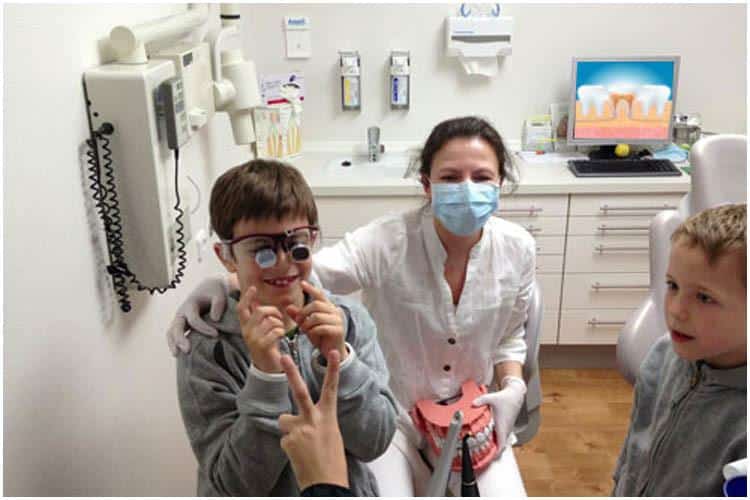 Ein Kind, das in einer Zahnarztpraxis eine kinderzahnmedizinische Behandlung erhält.