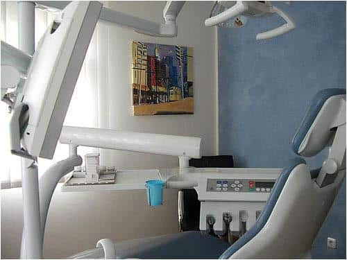 Ein Praxis-Zahnarztstuhl in einem Raum mit blauen Wänden.